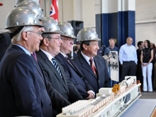 Chair Fisch and the other dignitaries pose for cameras in front of a scale model of a tunnel boring machine.