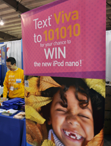 A member of team vivaNext talks to people at a booth at the Markham Home Show in front of our contest banner.