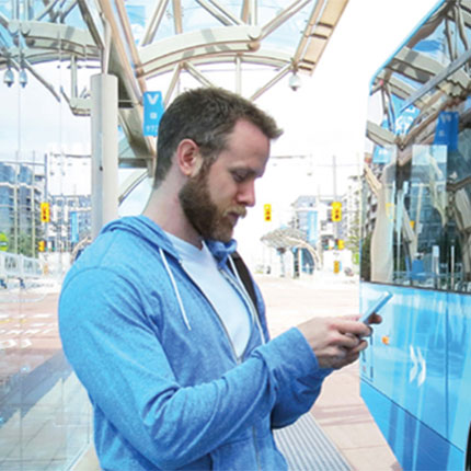 man checks his phone on station platform.